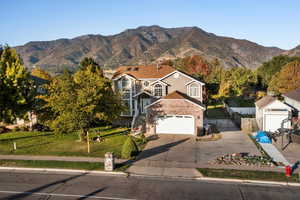 View of front of home featuring a mountain view, driveway, and brick siding