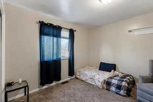 Carpeted bedroom with a textured ceiling and baseboards