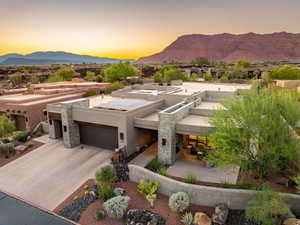 View of front of house with a mountain view, a patio area, stucco siding, stone siding, and concrete driveway