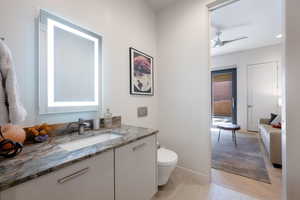 Half bath featuring vanity and ceiling fan