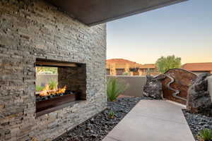 View of patio with an outdoor stone fireplace