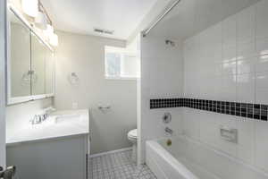 Bathroom with light tile patterned floors,  shower combination, and vanity