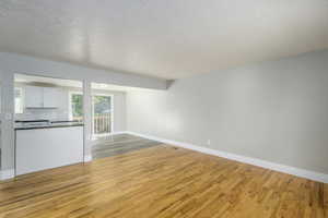 Unfurnished living room featuring light wood finished floors and a textured ceiling