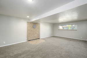 Unfurnished room featuring carpet and a textured ceiling