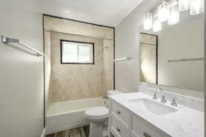 Bathroom featuring vanity, shower / bath combination, and dark wood finished floors