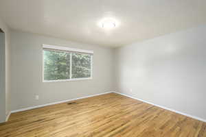 Spare room with light wood finished floors and a textured ceiling
