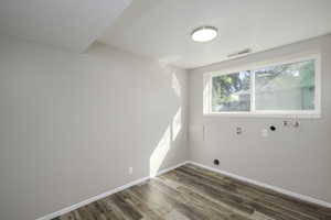 Laundry room with dark wood-type flooring and hookup for a washing machine