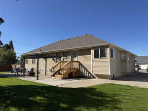 Rear view of property with a patio area and roof with shingles
