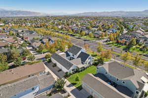 Aerial view of property and surrounding area featuring a mountain backdrop and nearby suburban area