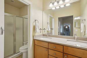 Bathroom featuring a stall shower, double vanity, and light tile patterned floors