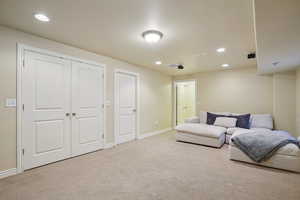 Carpeted living room with recessed lighting and baseboards