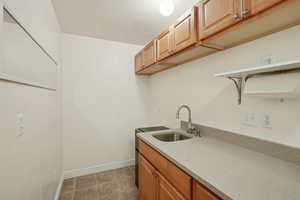 Laundry room with light tile patterned floors and baseboards
