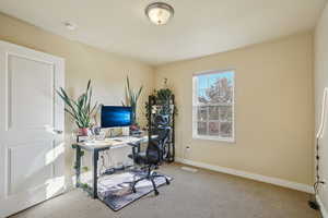 Home office with carpet floors and baseboards