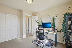 Home office with baseboards and light colored carpet