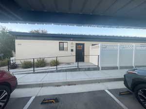 View of front of property with brick siding, uncovered parking, and a metal roof
