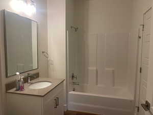 Full bath featuring washtub / shower combination and vanity