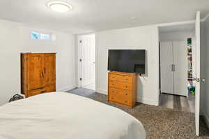 Carpeted bedroom with a textured ceiling and baseboards