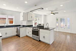 Kitchen with stainless steel appliances, white cabinetry, a peninsula, plenty of natural light, and recessed lighting