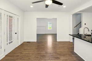 Unfurnished dining area with dark wood-type flooring, recessed lighting, and ceiling fan