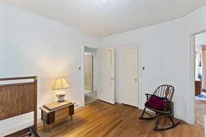 Living area with wood finished floors, a textured ceiling, and arched walkways