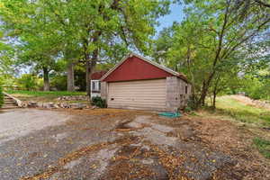 Detached garage with view of scattered trees