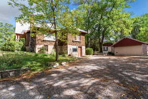 View of property exterior featuring brick siding and an outbuilding