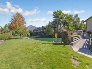 View of a grassy common area featuring a water and mountain view.