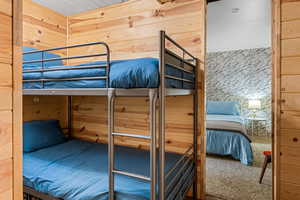 room with bunkbeds, room featuring wood walls