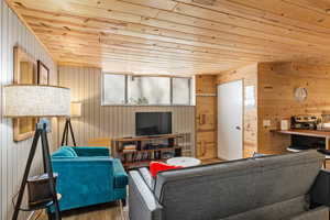 Unit 1b, living room featuring wood walls, wooden ceiling, and wood finished floors