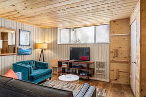Unit 1b, living area featuring wooden ceiling, wood finished floors, wood walls, and heating unit