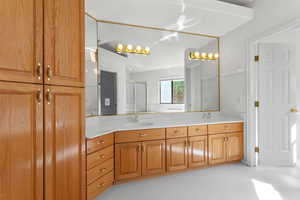 Full bathroom featuring double vanity, a shower stall, and light tile patterned floors