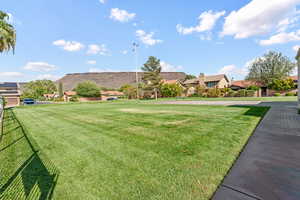View of green lawn with a residential view