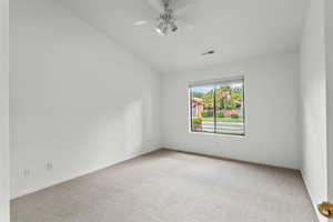 Unfurnished room featuring vaulted ceiling, light colored carpet, and a ceiling fan