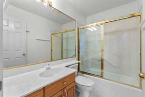 Bathroom with combined bath / shower with glass door and vanity