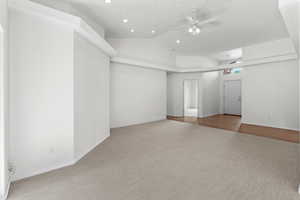 Empty room featuring carpet floors, ceiling fan, lofted ceiling, and recessed lighting