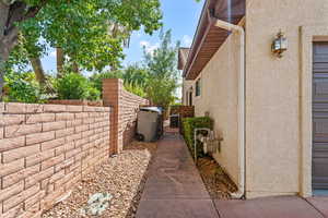 View of side of property featuring a gate and stucco siding