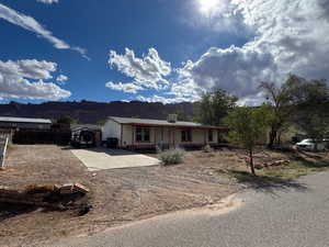Ranch-style home featuring GRAVEL driveway and a mountain view