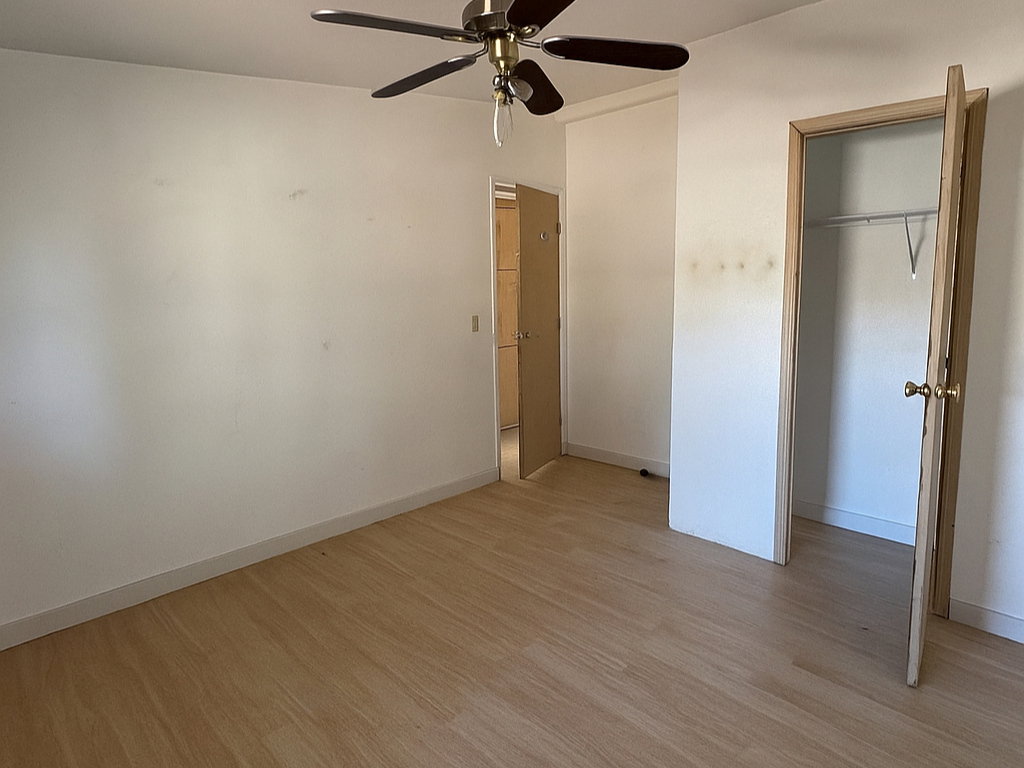 Unfurnished bedroom with light wood-style floors, a ceiling fan, and a closet