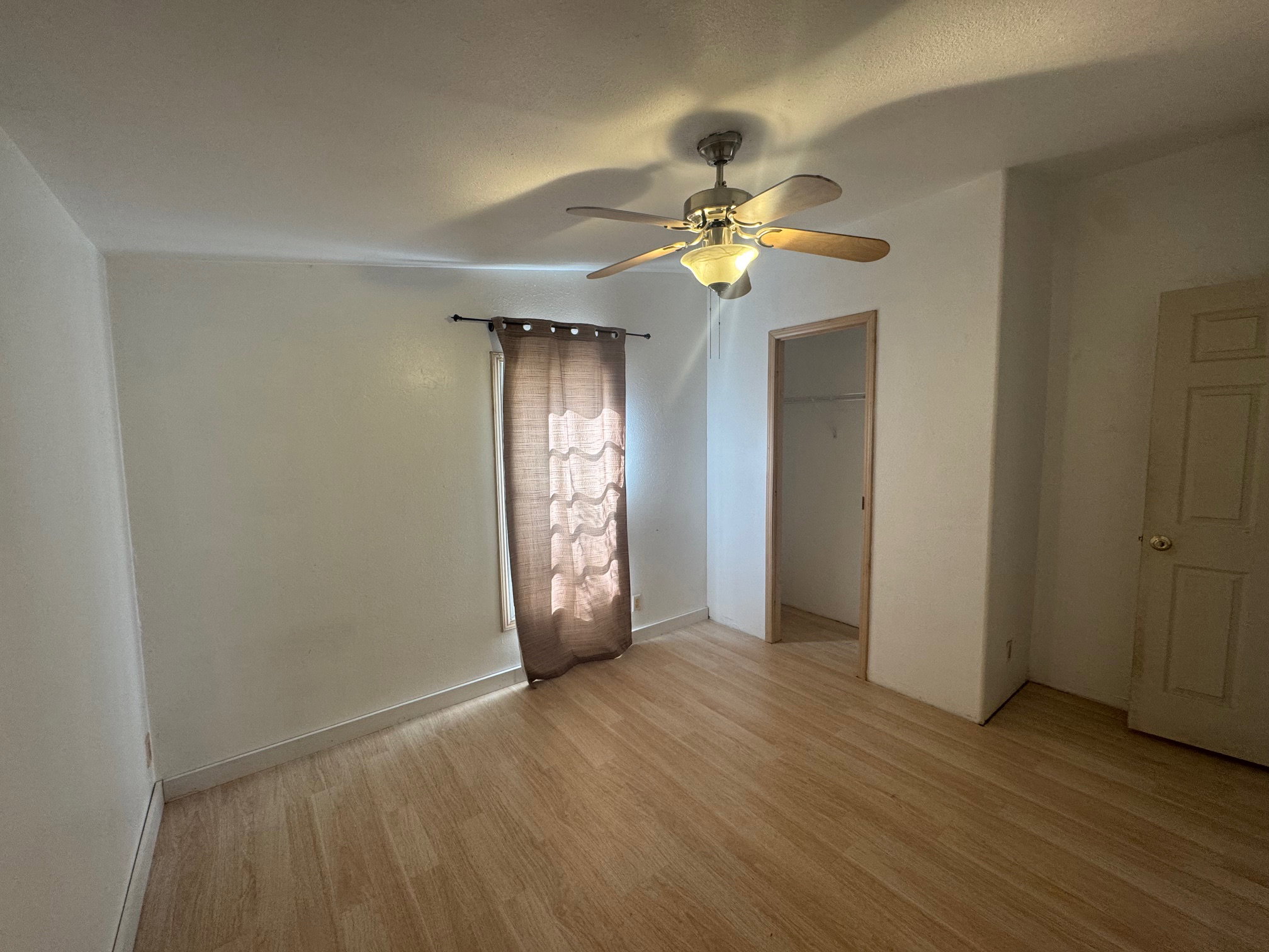 Unfurnished bedroom with light NEW LVP flooring and ceiling fan