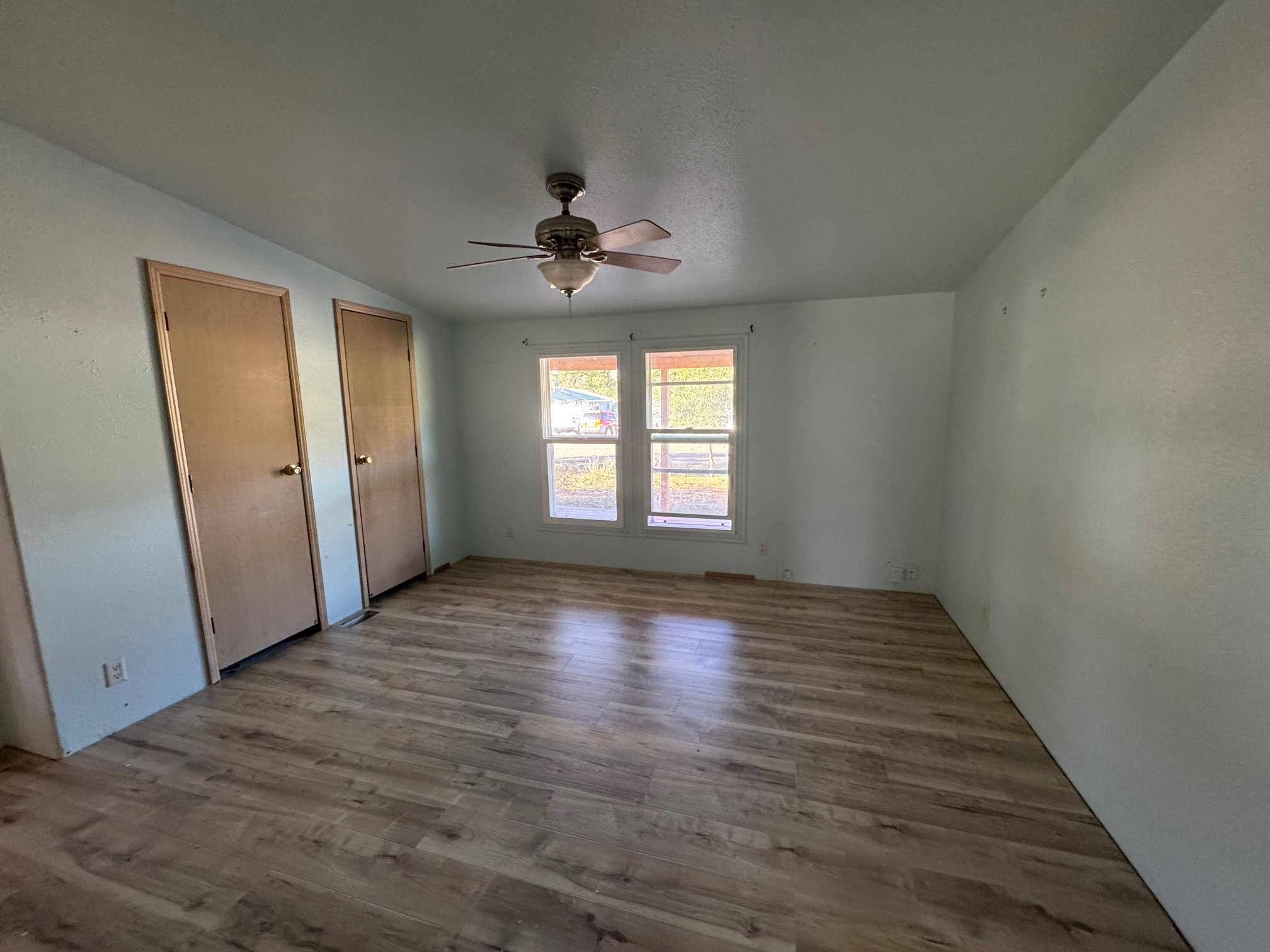 Unfurnished bedroom with multiple closets, NEW LVP finished floors, ceiling fan, and lofted ceiling