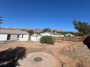Fenced backyard featuring a storage shed, a fire pit, and a mountain view
