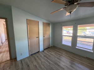 MASTER Unfurnished bedroom featuring lofted ceiling, multiple closets, LVP finished floors, and ceiling fan