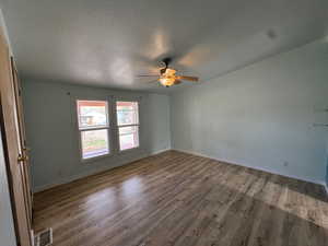 Unfurnished room featuring a textured ceiling, new floors, and a ceiling fan