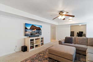 Living area featuring carpet floors, an office area, and ceiling fan