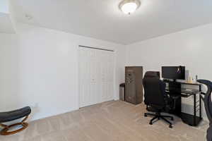 Office space with baseboards and light carpet
