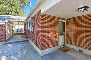 Property side entrance from garage  featuring brick siding
