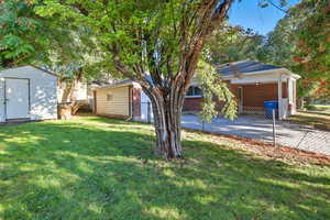 View of yard featuring a shed, garage, and home.