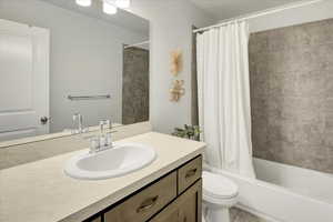 Bathroom featuring shower / bath combination with curtain, vanity, and light tile patterned floors