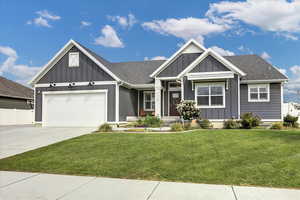 View of front of property with board and batten siding, concrete driveway, an attached garage, and roof with shingles
