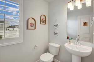 Half bath featuring toilet and baseboards